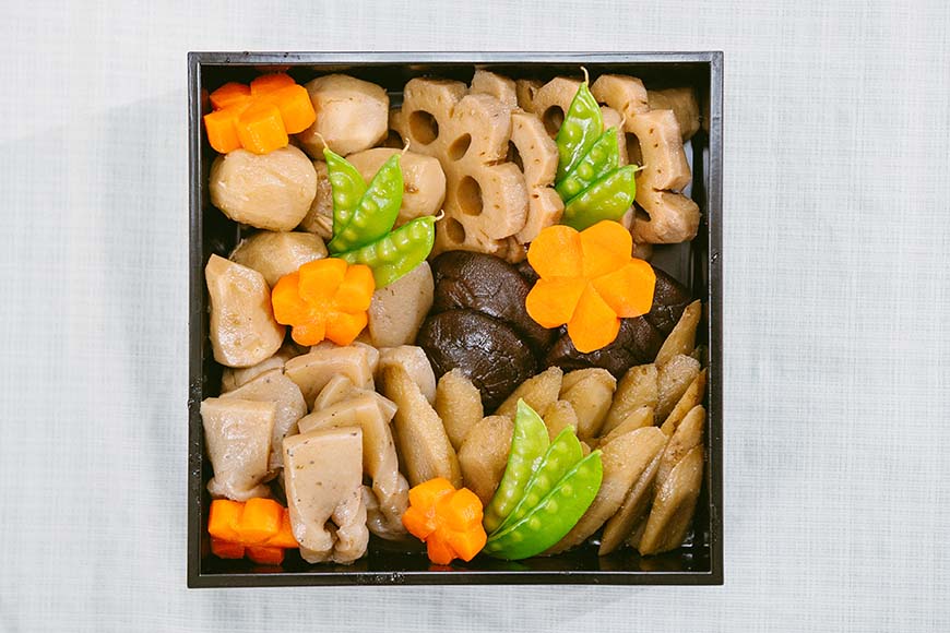 日本新年年菜使用漆器餐盒盛裝，將各式年菜一一放入，代表著層層疊疊的祝福，華麗而高雅。