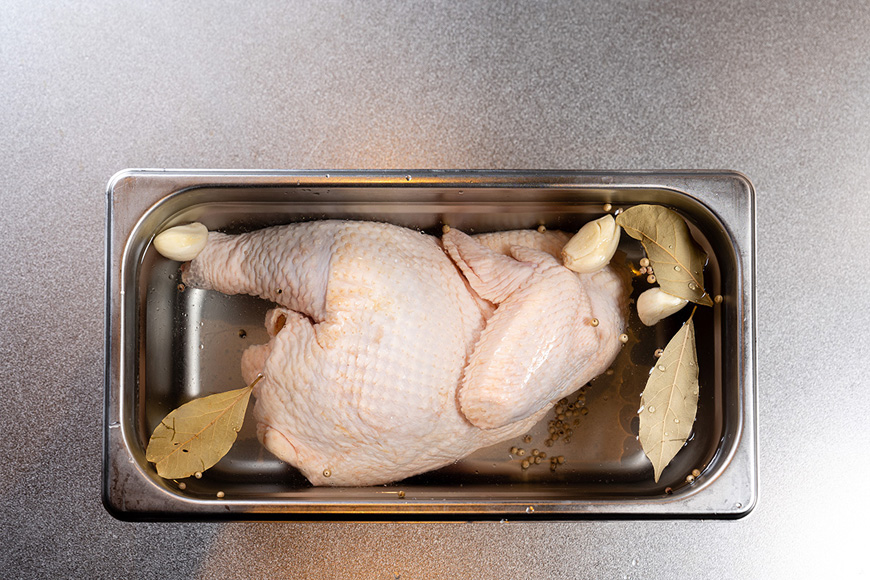 將半雞置於鹽水中，放冷藏浸泡 12 小時。